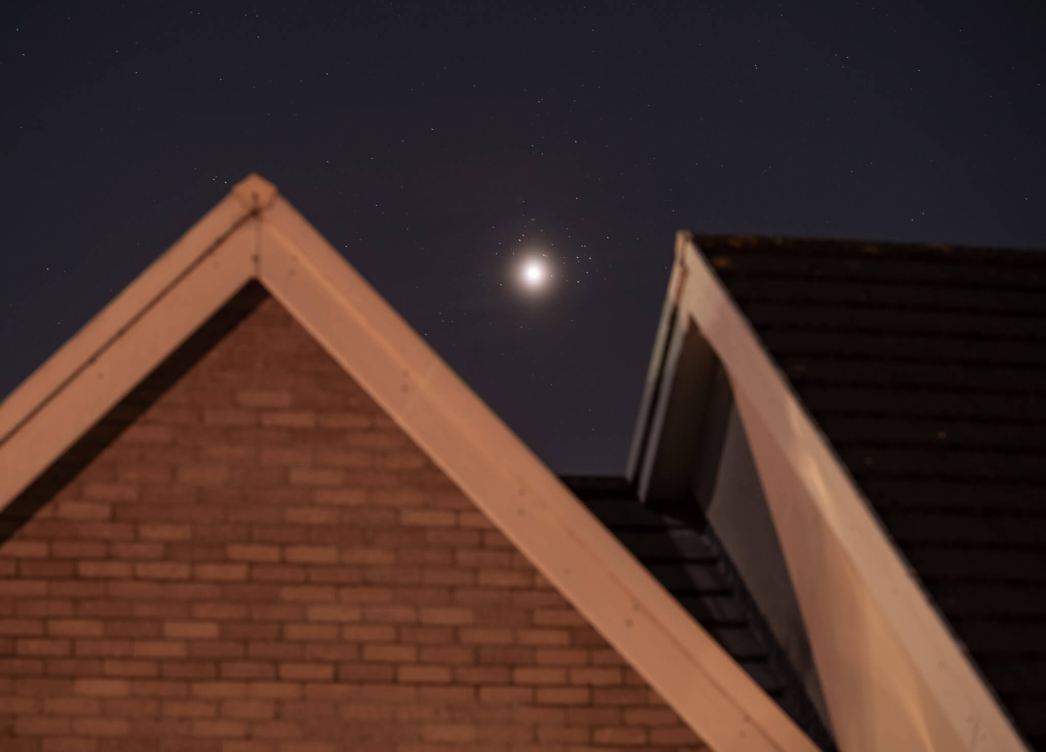 venus and pleiades above rooftops