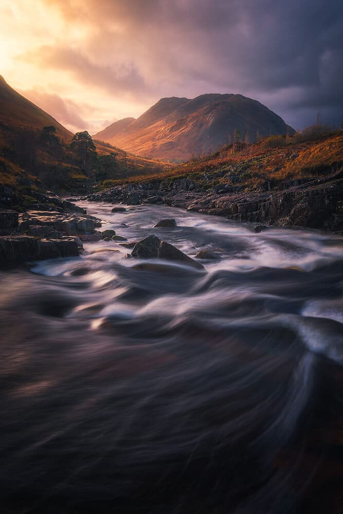 fast moving water in river with mountains in background