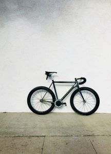 black bicycle against a light grey wall