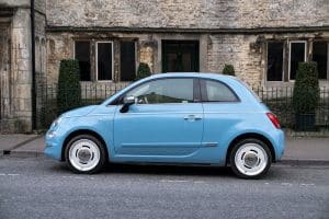 blue car in front of old building